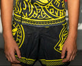 Child wearing a black and yellow patterned shirt with 'Butterfly' branding in front of a branded backdrop.
