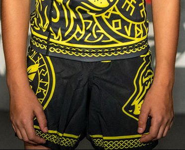 Child wearing a black and yellow patterned shirt with 'Butterfly' branding in front of a branded backdrop.